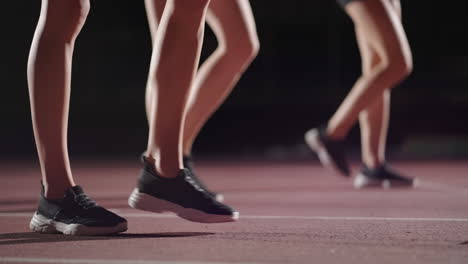 Close-up-of-the-legs-of-women-runners-in-sneakers-in-the-dark-near-the-start-line-preparation-and-strat-of-the-race